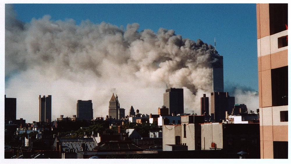 Dust and smoke across Lower Manhattan, with one tower still standing above the cloud